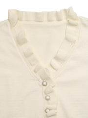 Close up flat lay of cream V neck knit top showing ruffle trim and pearl buttons