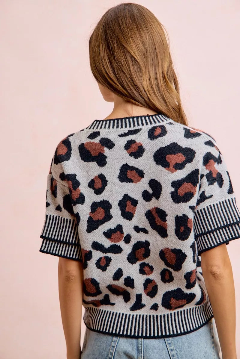 Back view of a light gray leopard print knit top with striped trim.