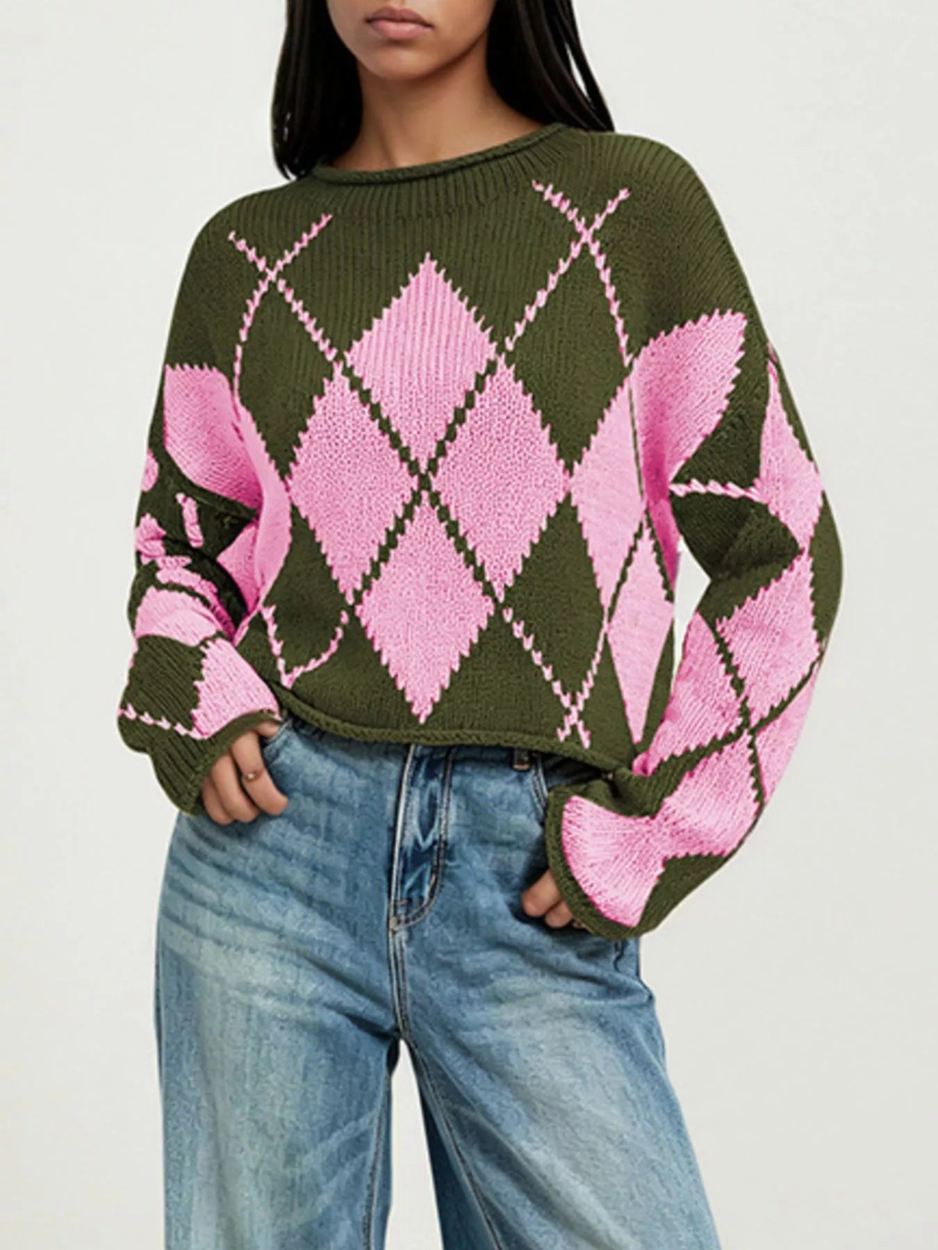 On-model front view of the olive and pink argyle sweater with hands in the jeans pockets