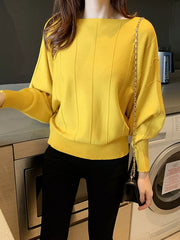 Front angled view of the yellow batwing sleeve knit top with vertical seams and ribbed hem.