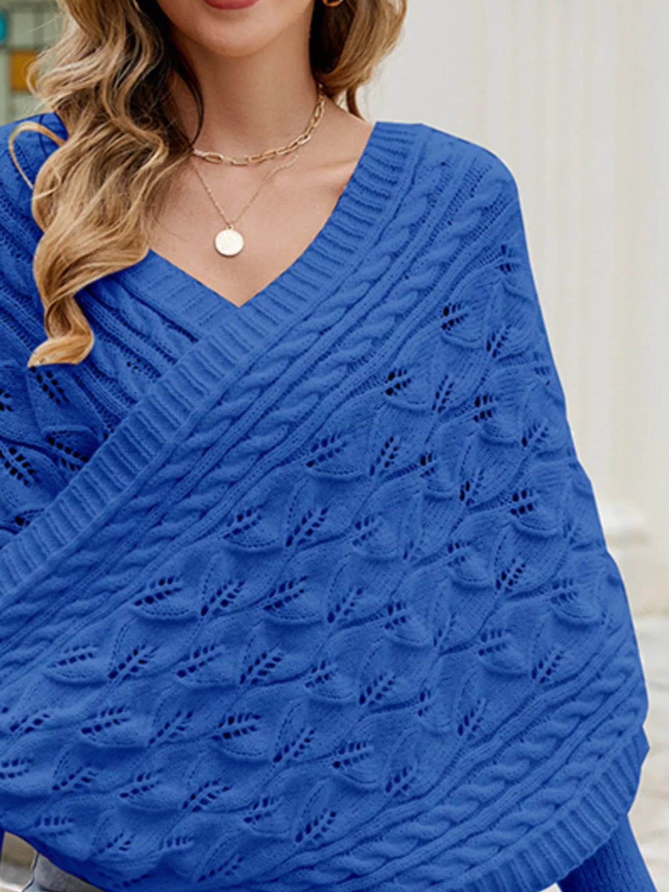 Close up of blue batwing sweater V neckline with cable and leaf openwork knit.