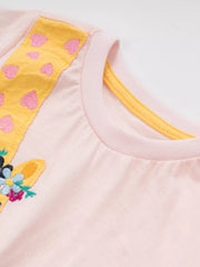 Close-up of the blush pink children's t-shirt neckline with yellow trim and giraffe appliqué