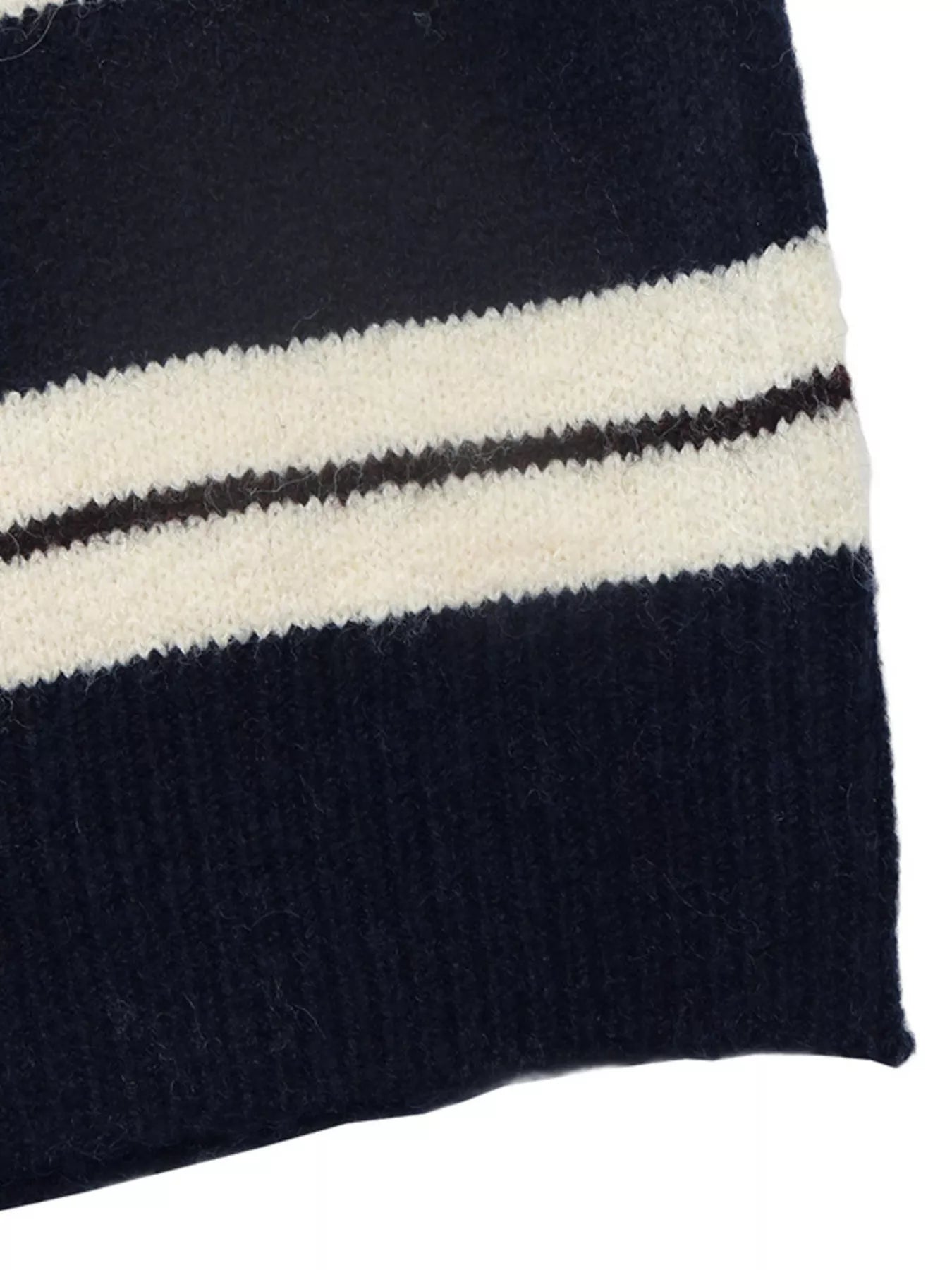 Close-up of the striped knit fabric and ribbed hem in navy and cream