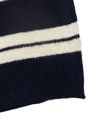 Close-up of the striped knit fabric and ribbed hem in navy and cream