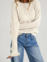 On-model front view of beige pointelle knit sweater with leaf pattern and flared cuffs