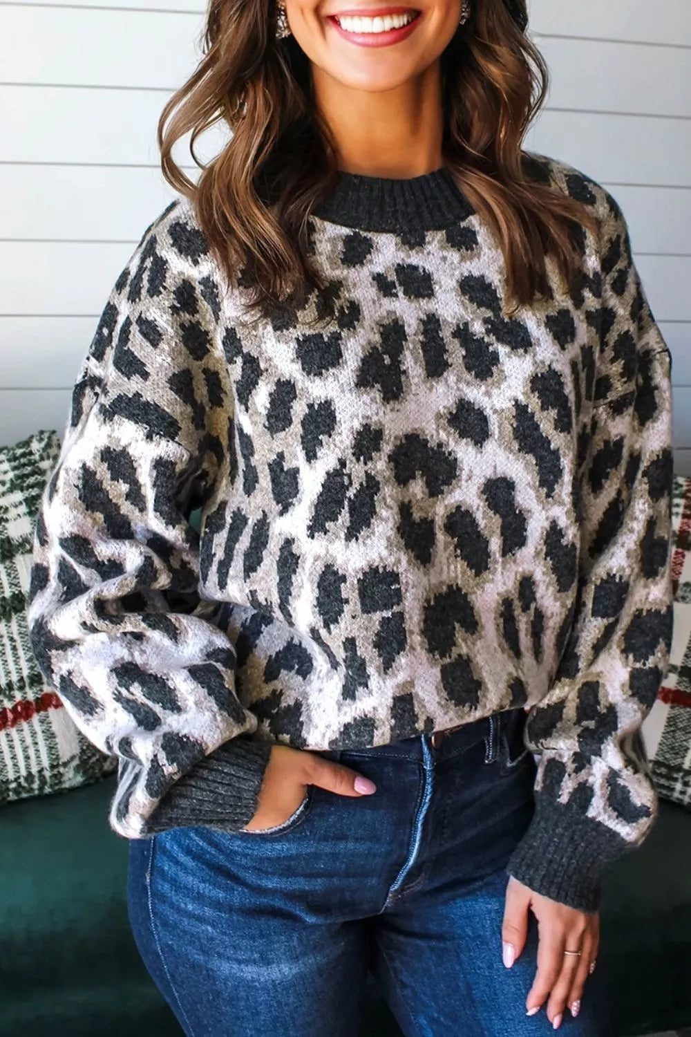 Close front view of the gray and black leopard print baggy sweater with ribbed collar, indoors.