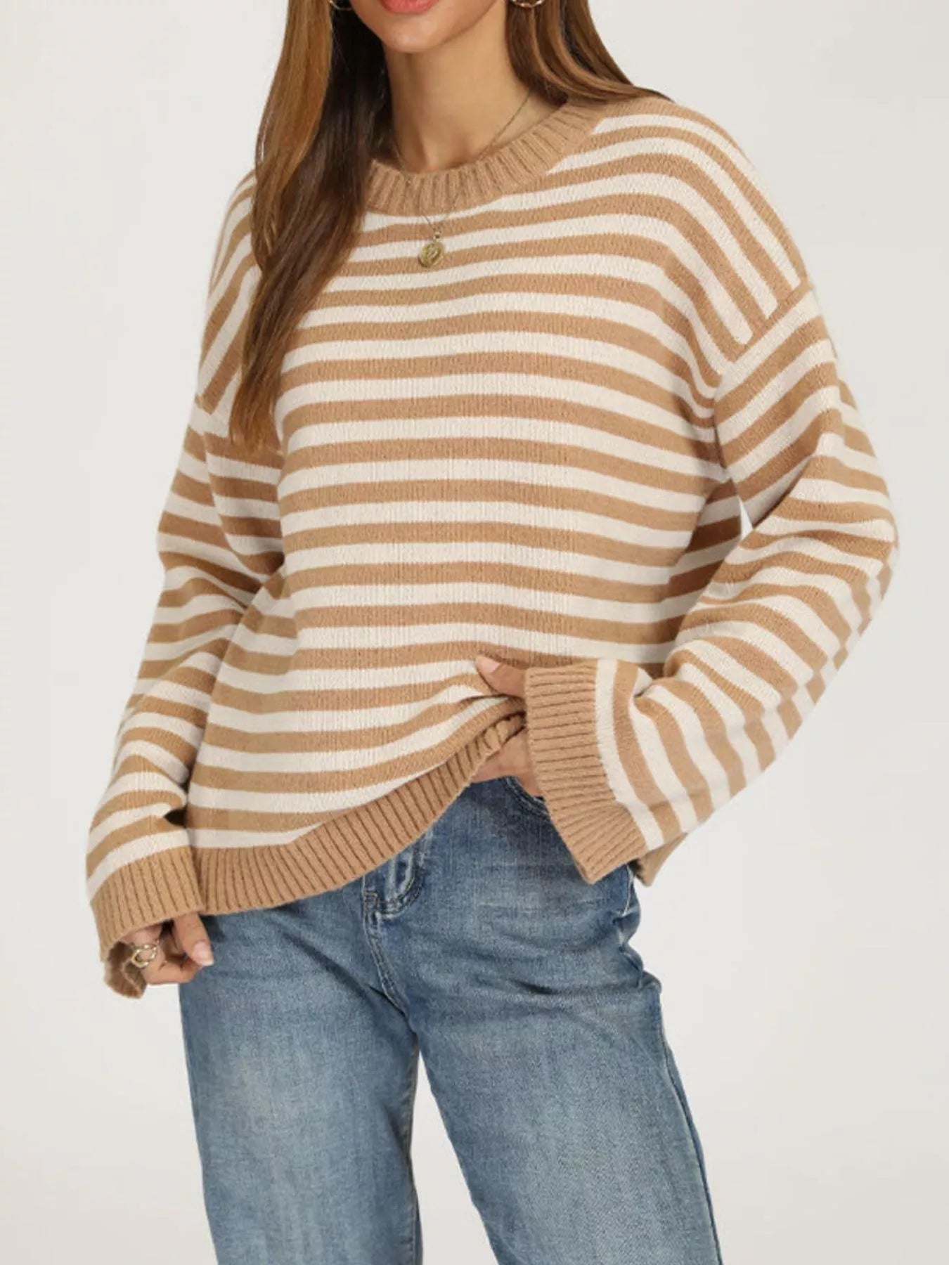 Front angled view of the khaki and white striped sweater with dropped shoulders and ribbed trim.