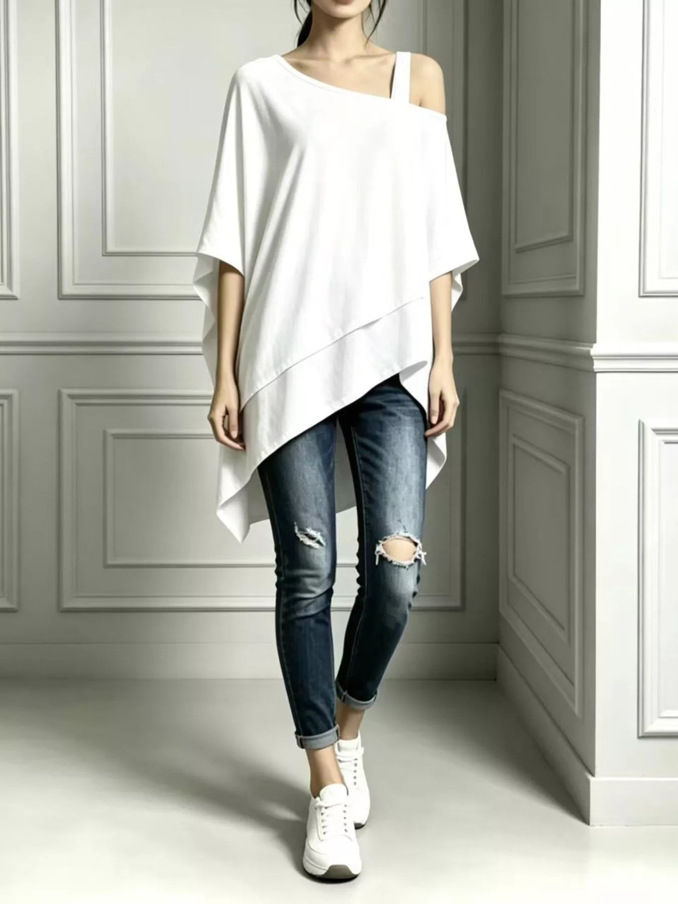 White asymmetrical-neck short-sleeve tunic top styled with distressed jeans and white sneakers, front view