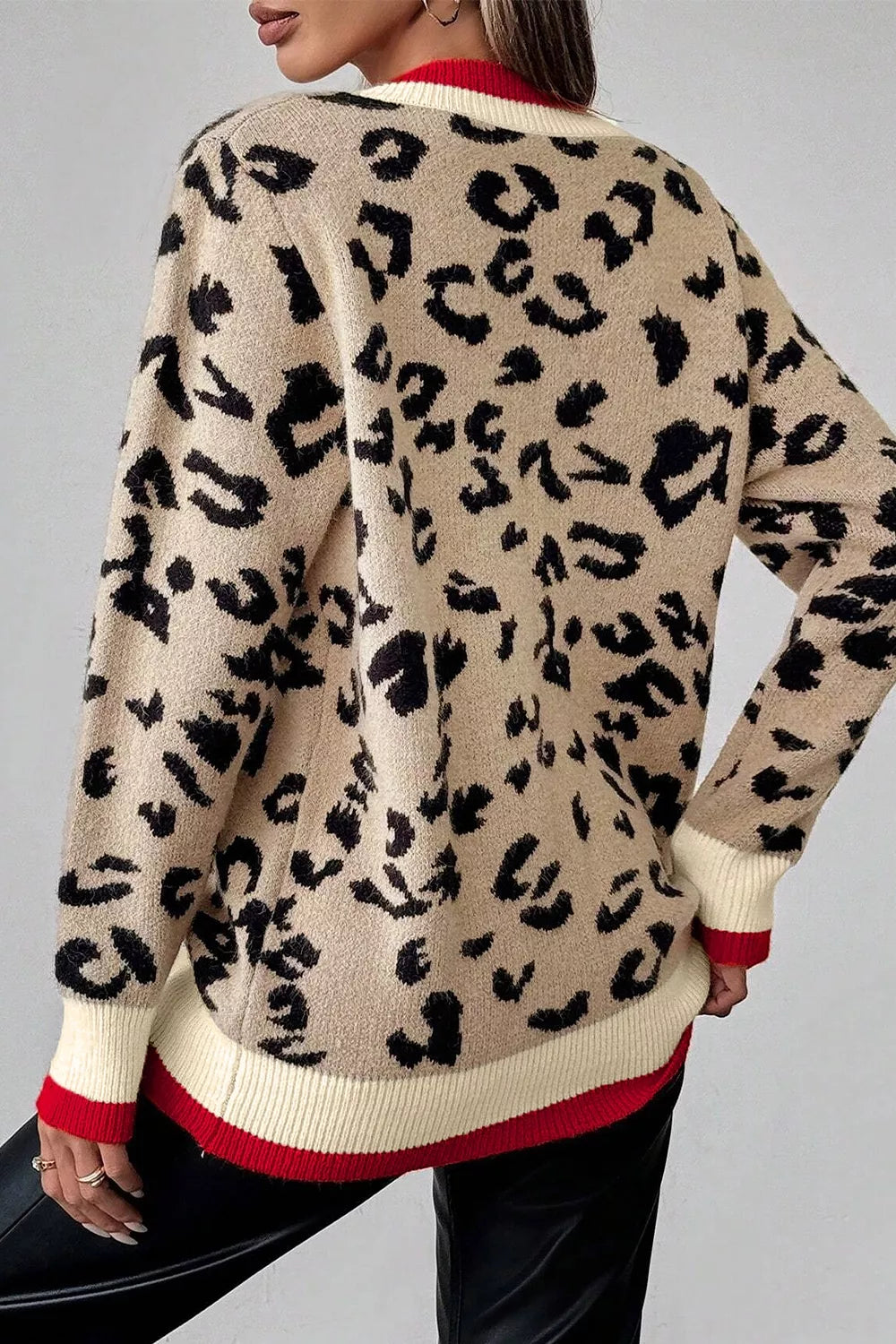 Back view of beige leopard print knit sweater with red and cream ribbed trim.