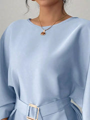 Close view of light blue round neck blouse showing neckline and gold buckle belt