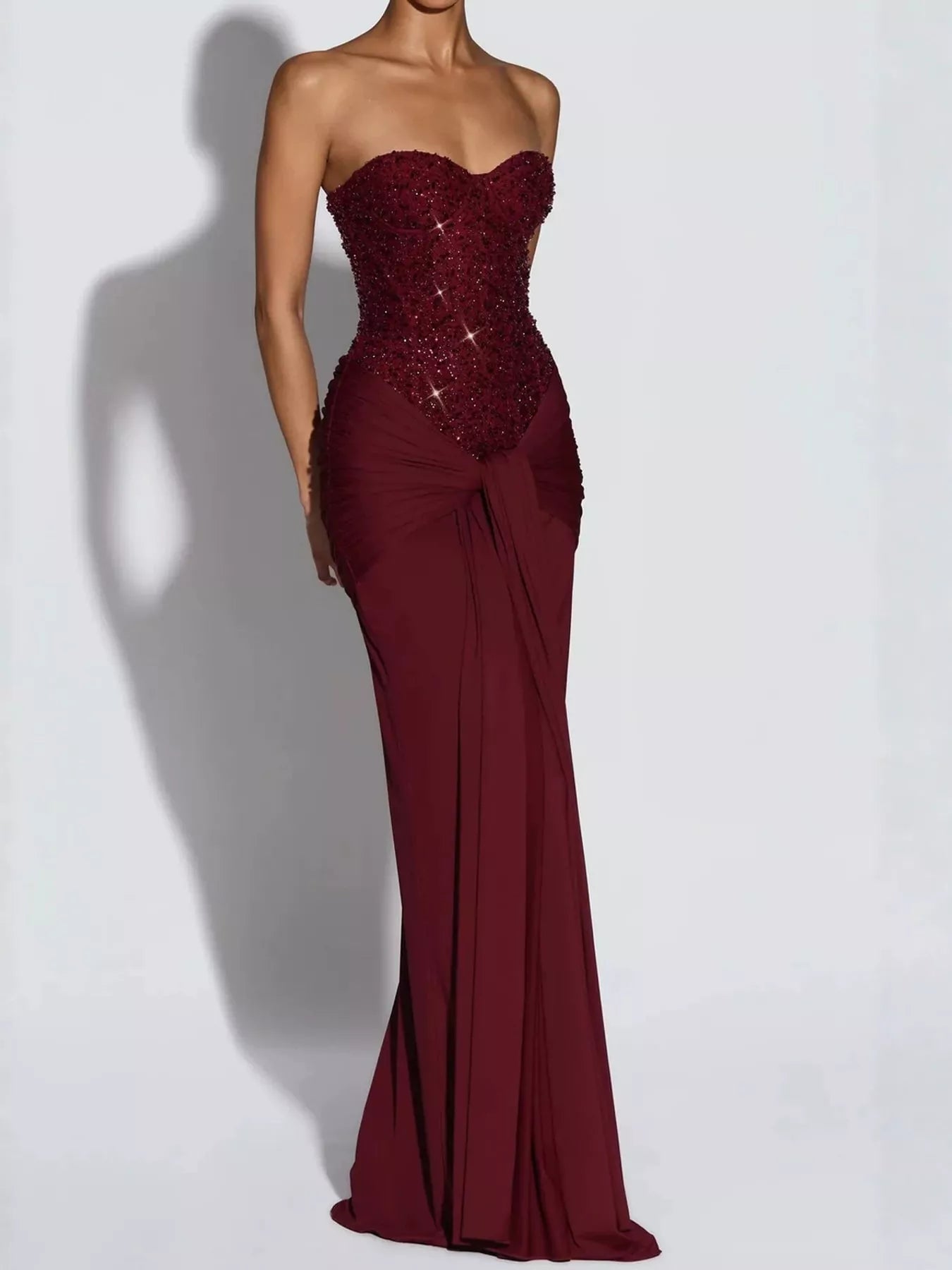 Red strapless sequin corset maxi dress with draped waist on model, studio front view