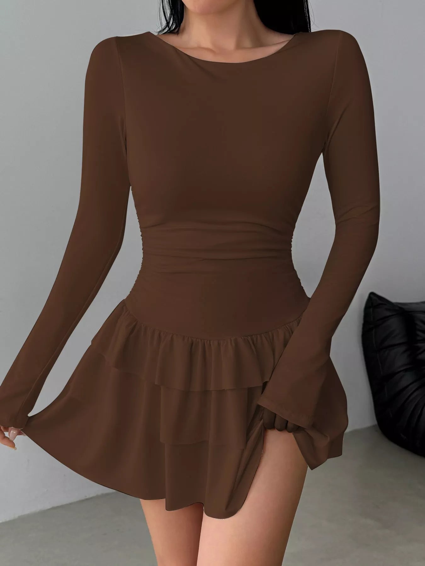 Coffee long sleeve mini dress worn front facing while holding out the tiered ruffle skirt