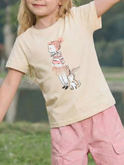 Cream children's short sleeve T-shirt shown worn outdoors with a striped top and rabbit graphic on the front
