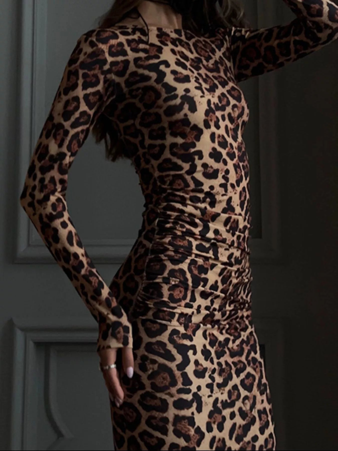 Close side view of the leopard print long sleeve bodycon midi dress showing ruched waist detail