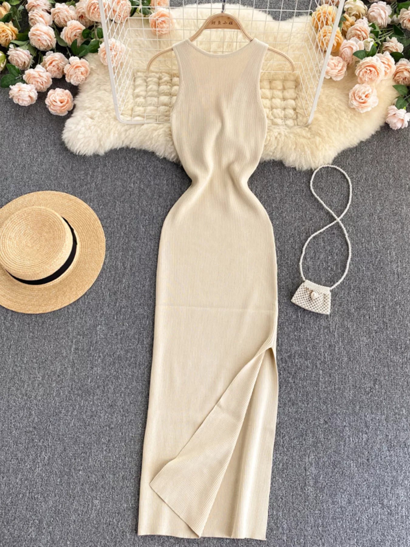 Cream white sleeveless knit bodycon midi dress, front view with side slit on hanger