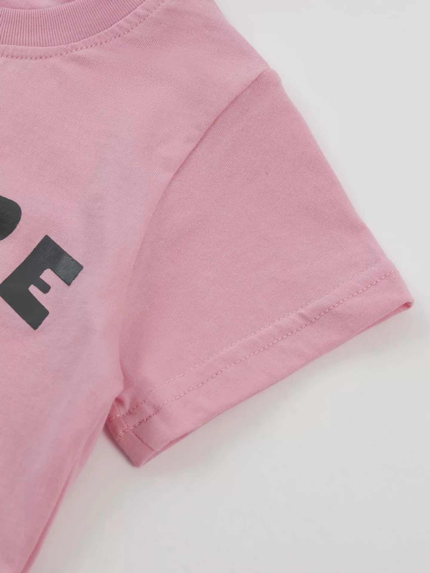 Close up of the pink short sleeve hem and double stitching on the children's T-shirt