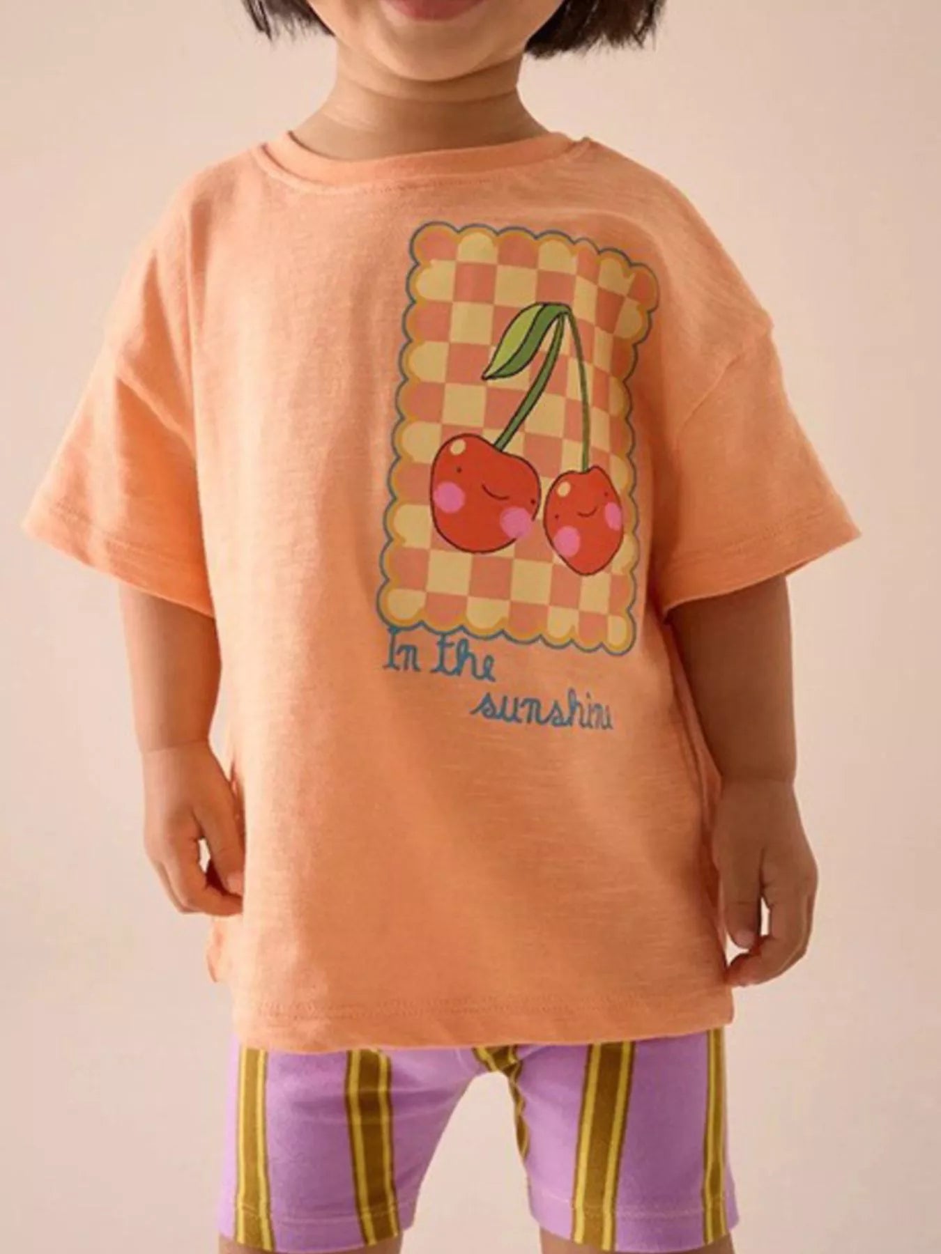 Children's orange round-neck T-shirt featuring a cherry design.