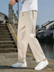 Men's khaki loose-fit casual pants with a drawstring waist and pockets.