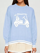 Front view of a light blue dropped shoulder sweater with a white golf cart graphic and striped trim.