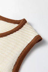 Close up detail of a beige sweater vest armhole with brown contrast trim