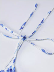 Close up of blue floral print tie straps tied in a knot on white background