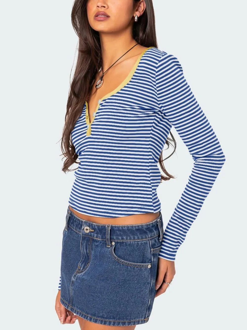 Three quarter side view of royal blue and white striped long sleeve t shirt with pale yellow V neckline trim