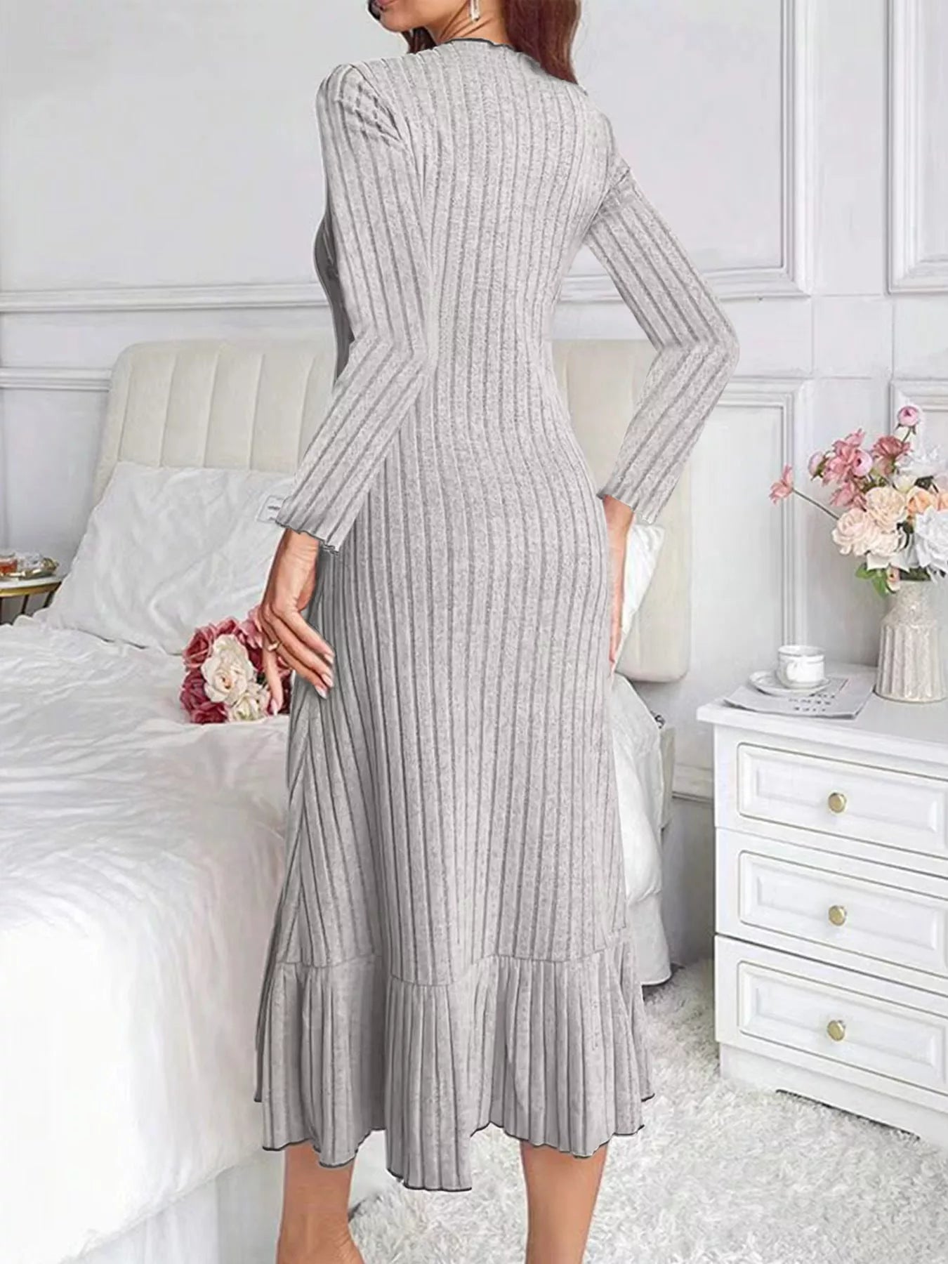 Back view of light gray ribbed knit bodycon dress with ruffle hem indoors