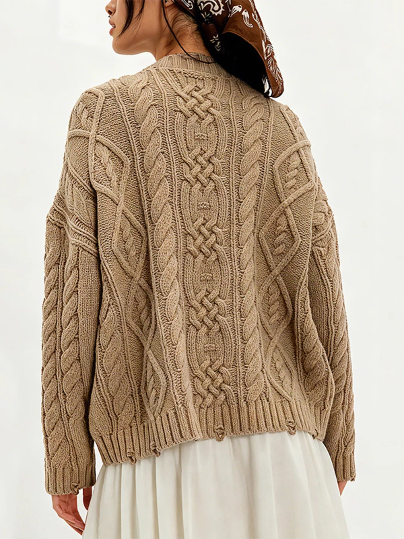 Back view of khaki cable knit sweater with cable pattern and white skirt