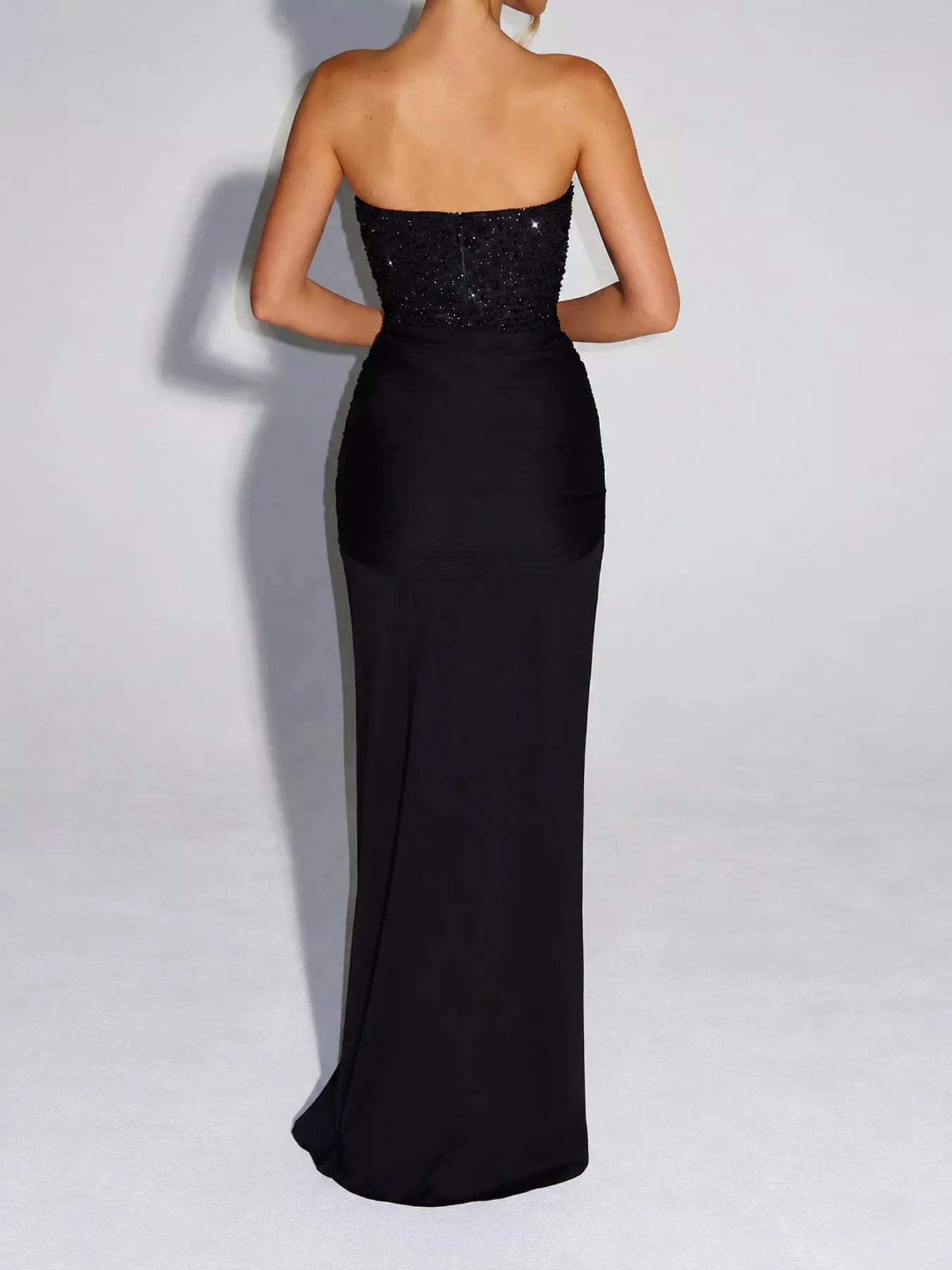 Black strapless sequin corset maxi dress on model, full length back view showing zip