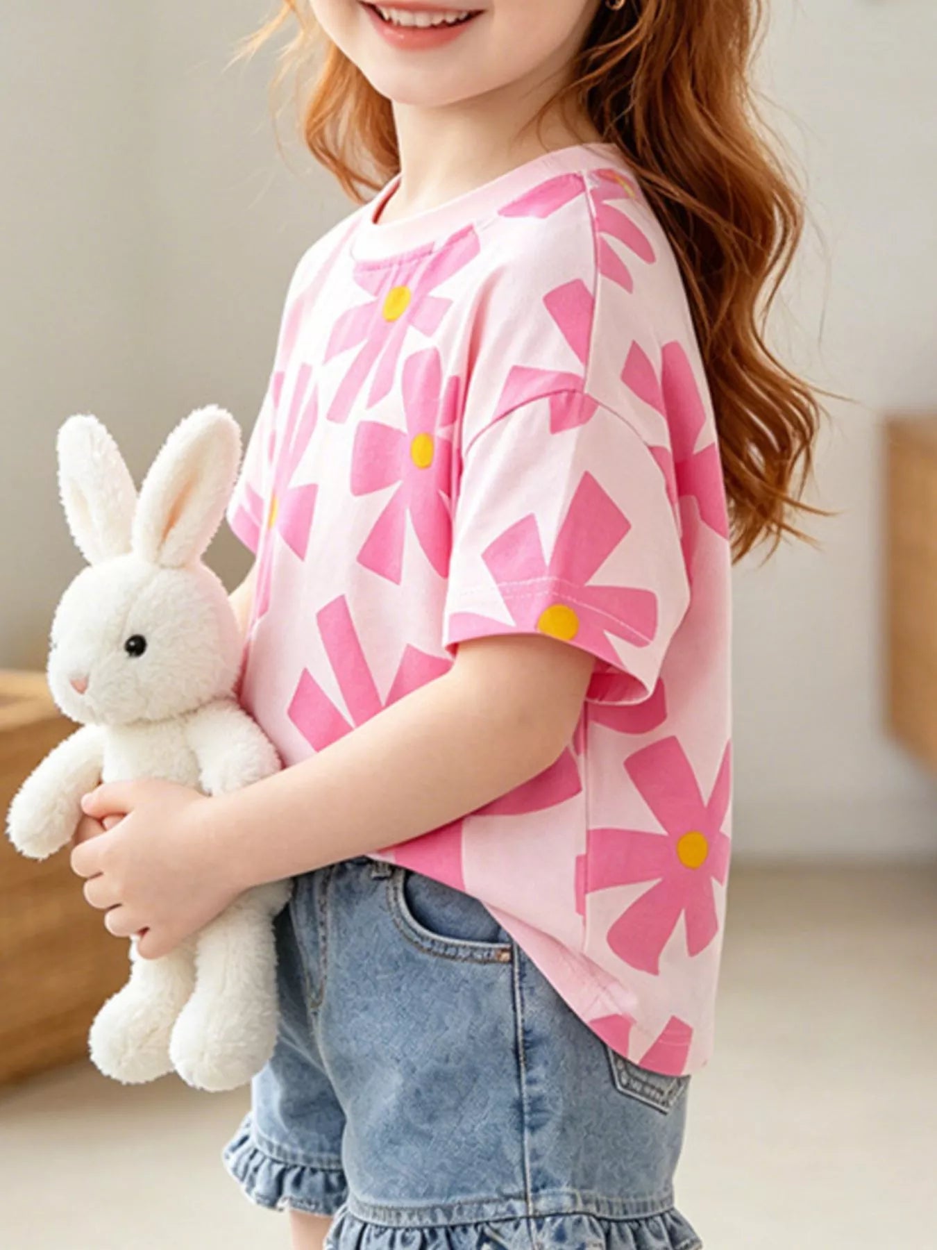 Side view of pink children's t-shirt with large pink flowers and yellow centers