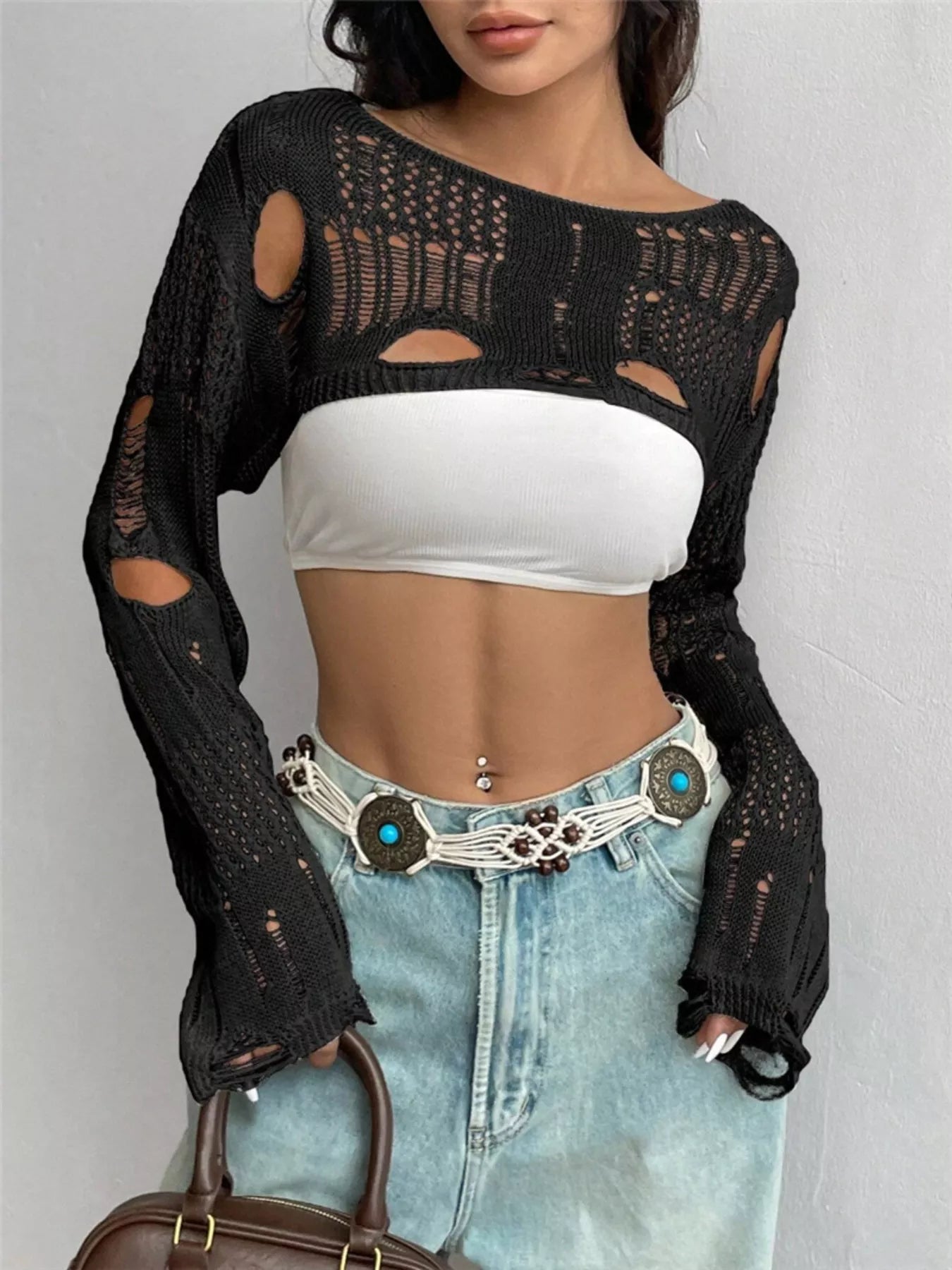Front view of black distressed cropped knit cover up with openwork and cutouts.