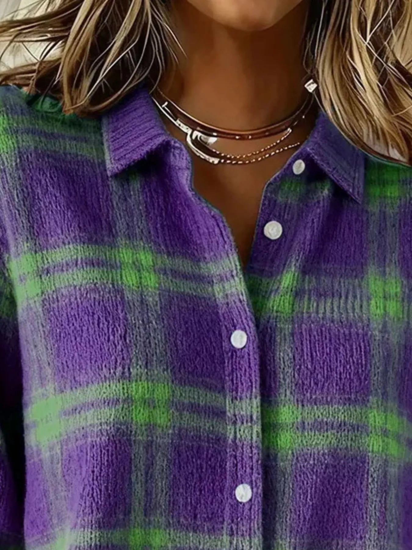 Close-up of the collar and button placket on a purple and green plaid knit cardigan