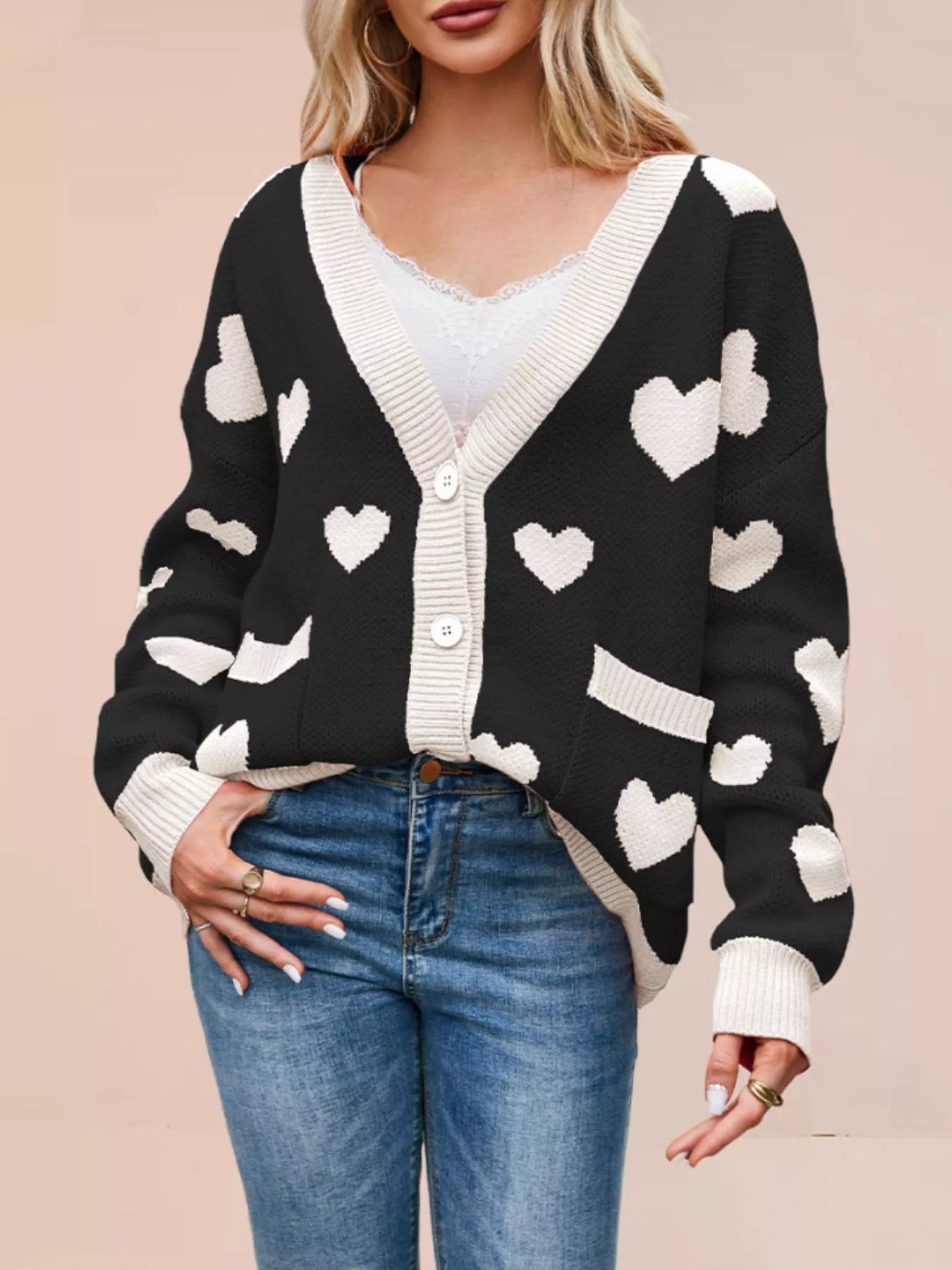 Black knit cardigan with white hearts buttoned in a V neck style