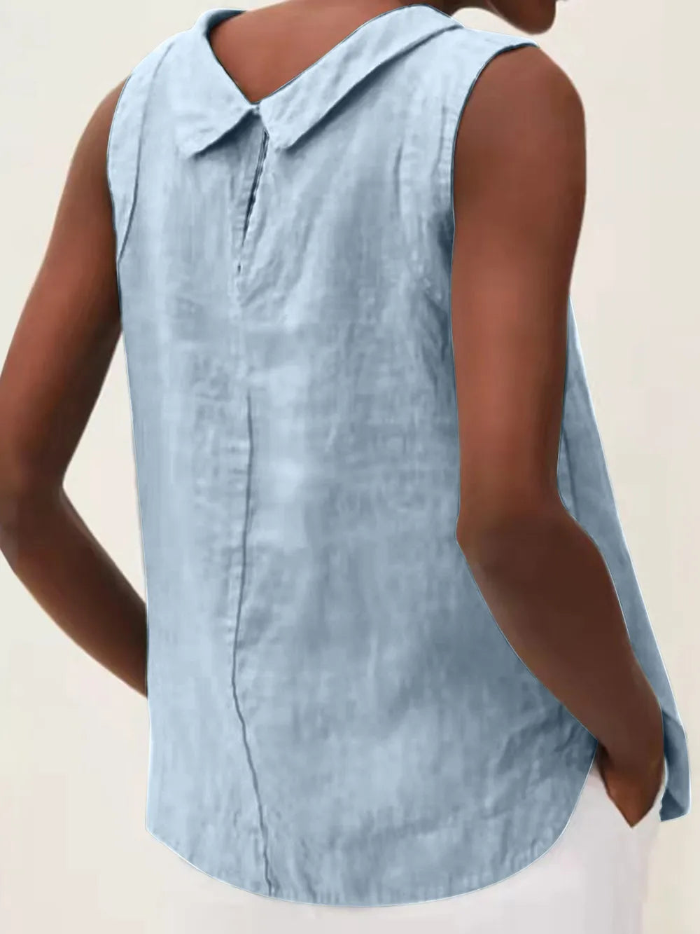 Back view of a light blue sleeveless top with a collar, button placket, and curved hem