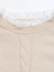 Close up of beige cable knit sweater dress neckline with white lace trim and ribbed collar