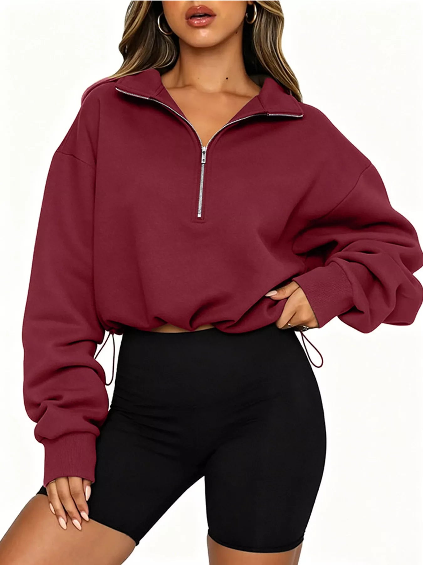 Front angled view of burgundy half zip sweatshirt with drawstring hem and long sleeves