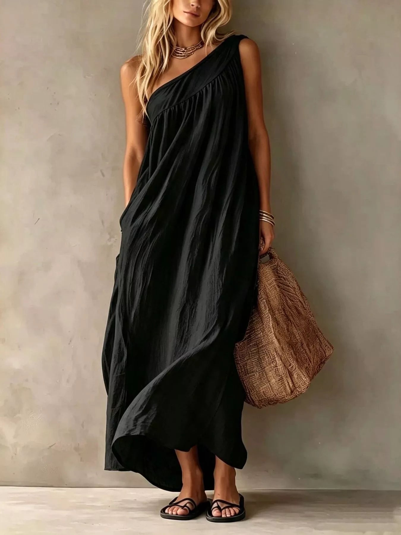 Full length front view of a black one shoulder maxi dress with gathered bodice on a model