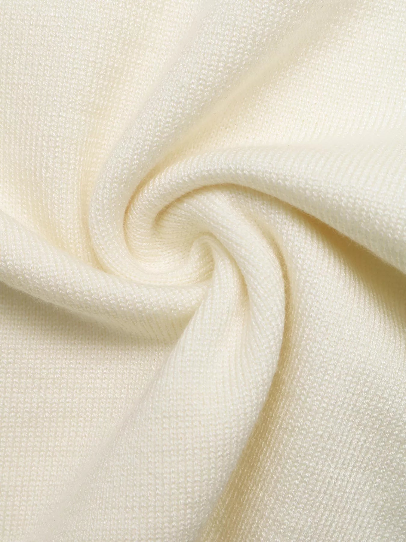 Close up of cream knit fabric showing soft fine texture and drape detail