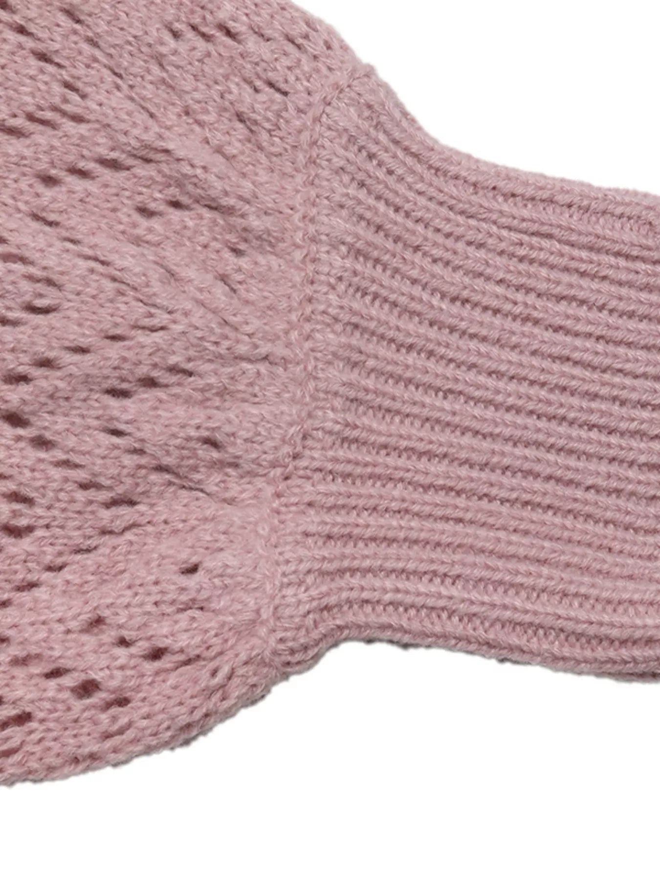Close up of a pink openwork sleeve and ribbed cuff on the V neck sweater.