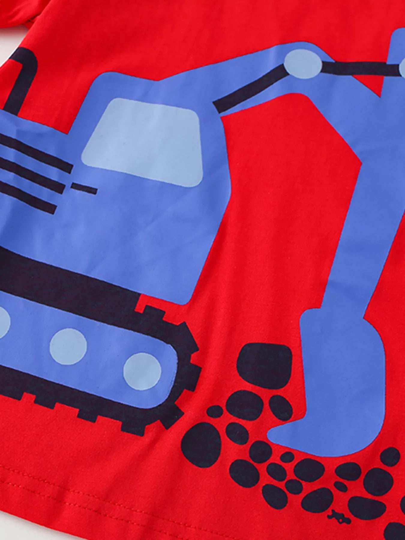Close up of the blue excavator cab, tracks and black dirt dots on a red children's tee