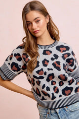 Front view of a light gray leopard print knit top with one hand behind the back.