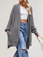 Gray long open front cardigan worn walking with hand in pocket