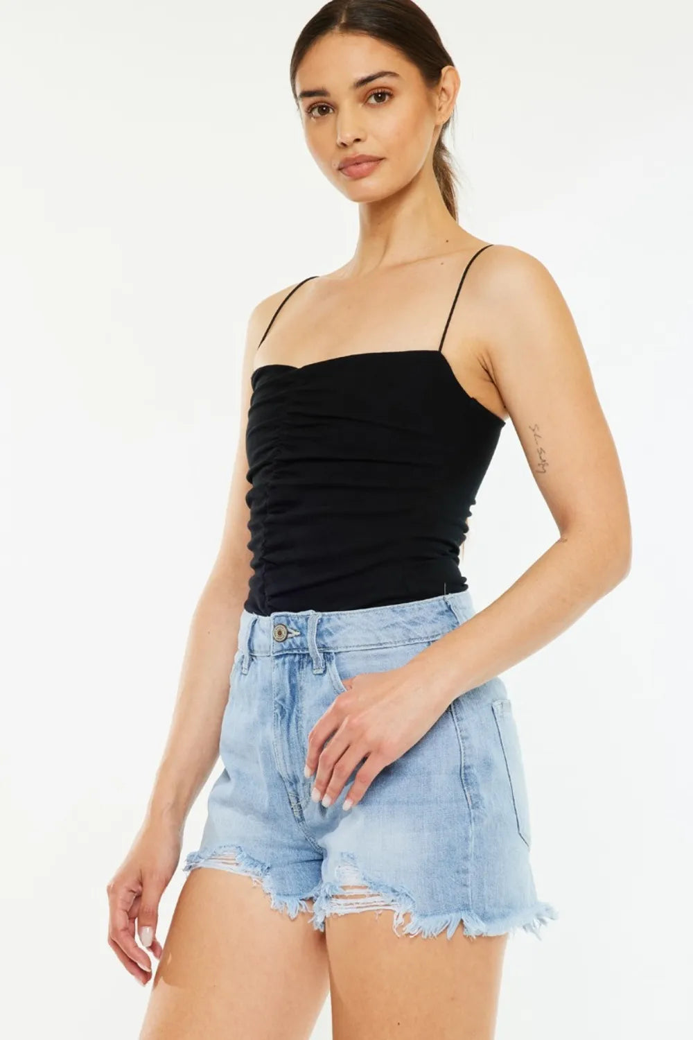 Women's distressed high-waisted denim shorts with washed detailing, pockets, and raw hems.