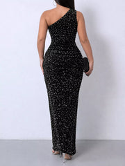 Black sequin one shoulder evening dress worn from the back holding a black clutch