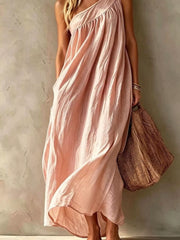 Lower view of a blush pink one shoulder maxi dress showing the flowing skirt and hem