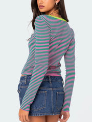Back view of green and pink striped long sleeve t shirt with lime neckline trim worn on model
