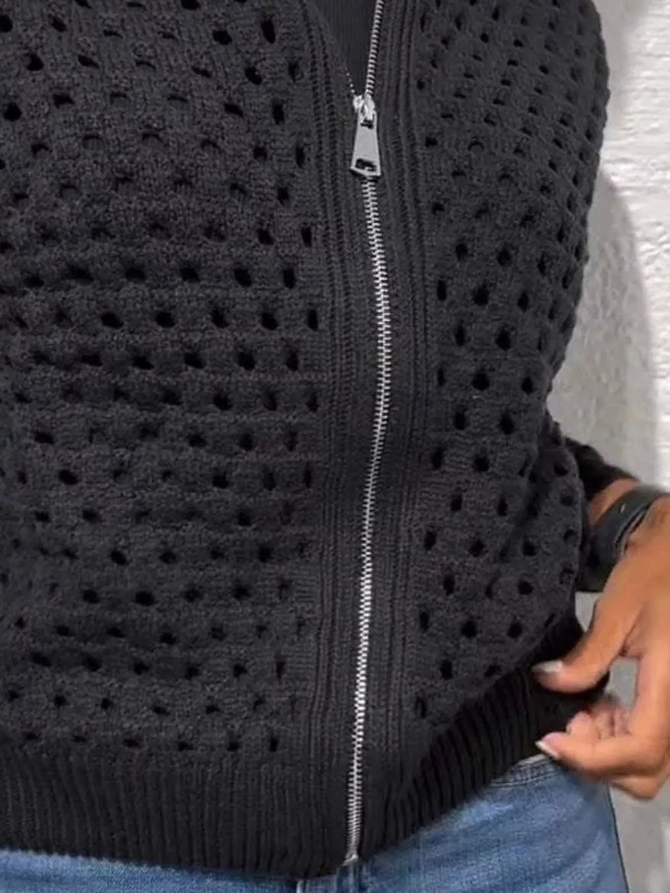 Close up of the black crochet cardigan lower zip and ribbed hem