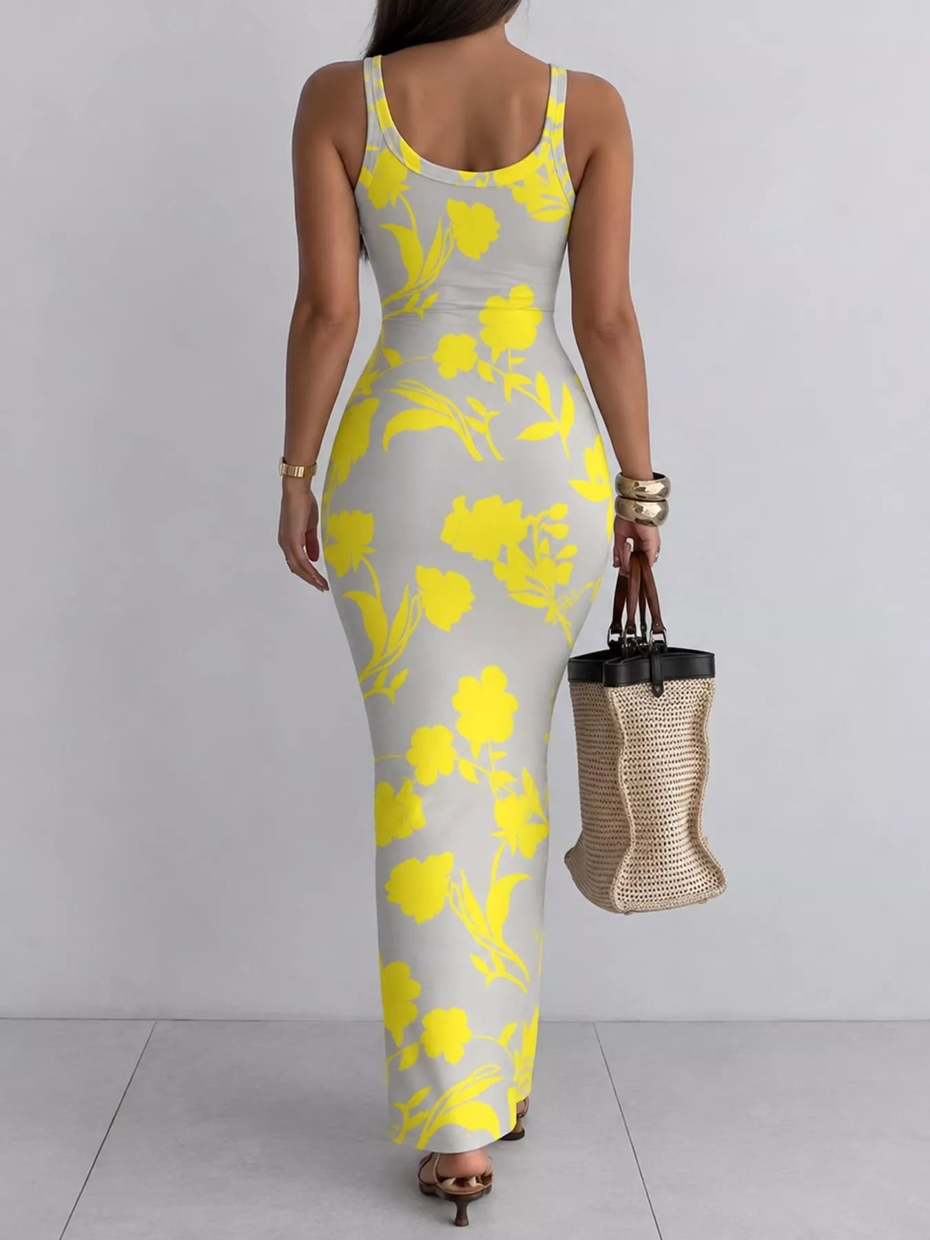 Grey sleeveless bodycon maxi dress with bold yellow floral print viewed from behind
