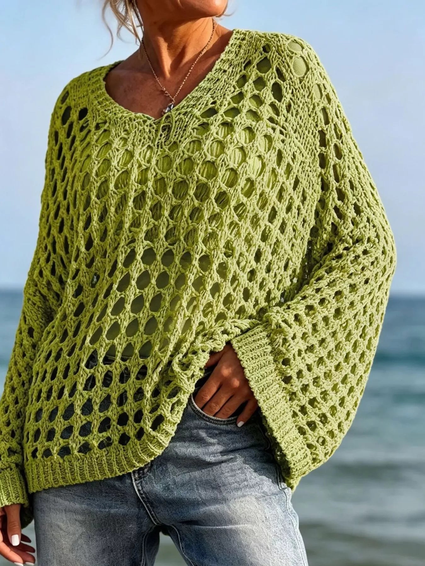 Front view of lime green openwork crochet knit cover up with V neck at the beach.