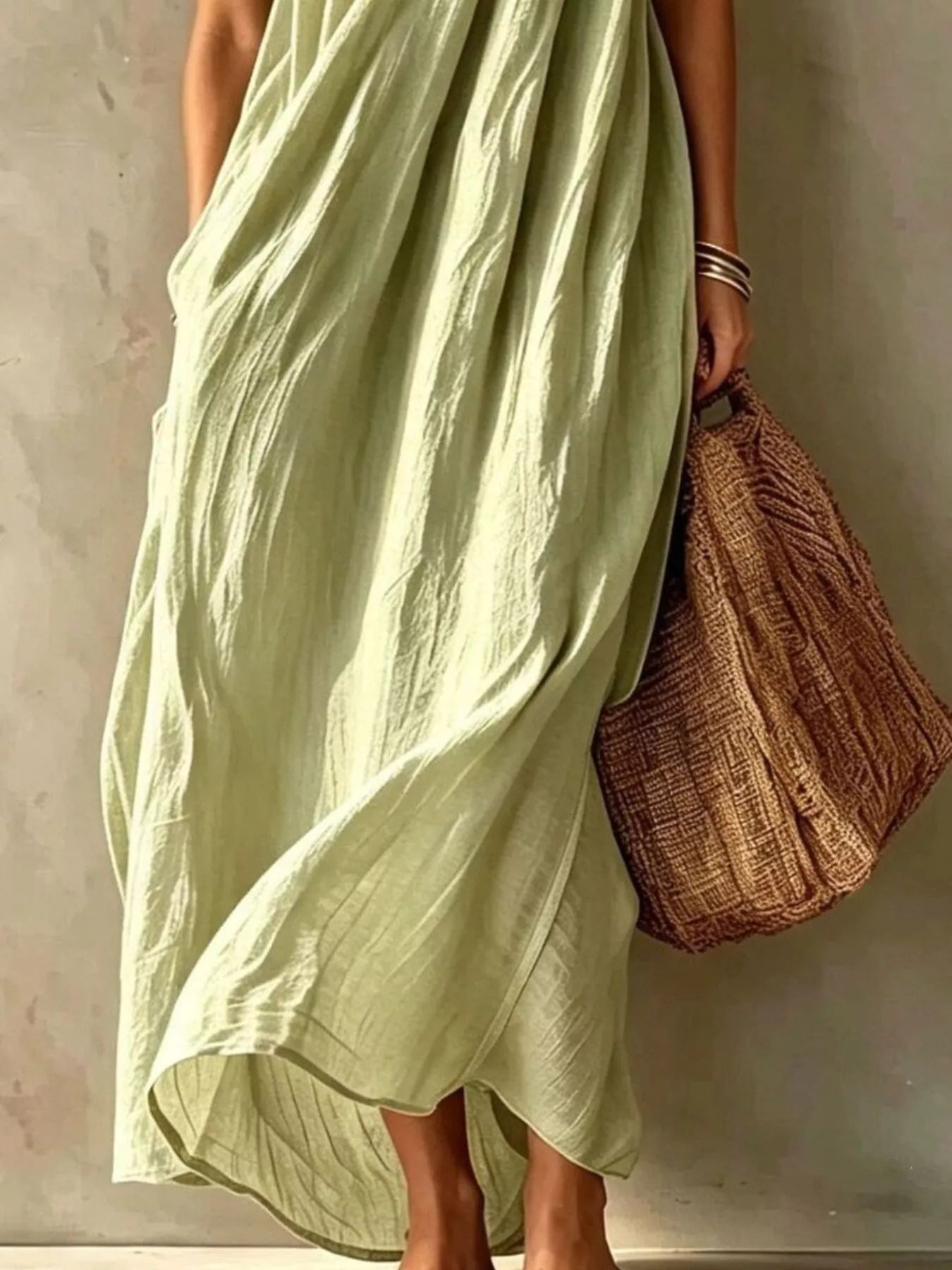 Lower view of a sage one shoulder maxi dress showing the flowing skirt and hem